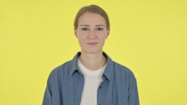 Mujer joven sintiéndose sorprendida sobre fondo amarillo — Vídeos de Stock