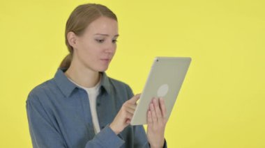 Sarı Arkaplan Tabletinde Başarıyı Kutlayan Genç Kadın 