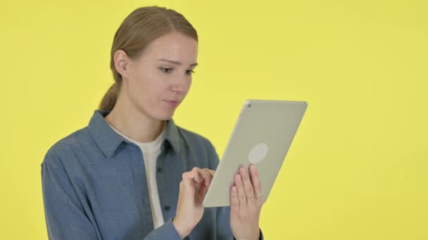 Молода жінка використовує цифровий планшет на жовтому тлі — стокове відео