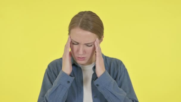 Mujer joven con dolor de cabeza sobre fondo amarillo — Vídeos de Stock