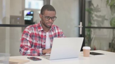 Laptop kullanırken Afrikalı Adam öksürüyor 