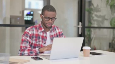 Laptop kullanırken Afrikalı Adam Kameraya Bakıyor