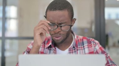 Dizüstü bilgisayar kullanırken Afrikalı Adam 'ın Baş Ağrısının Kapanışı
