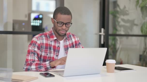 African Man Κοιτάζοντας Κάμερα ενώ χρησιμοποιείτε Laptop — Αρχείο Βίντεο