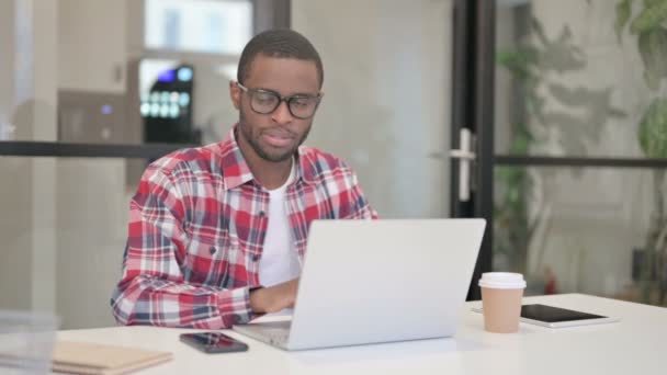 Hombre africano se siente sorprendido mientras se utiliza el ordenador portátil — Vídeos de Stock
