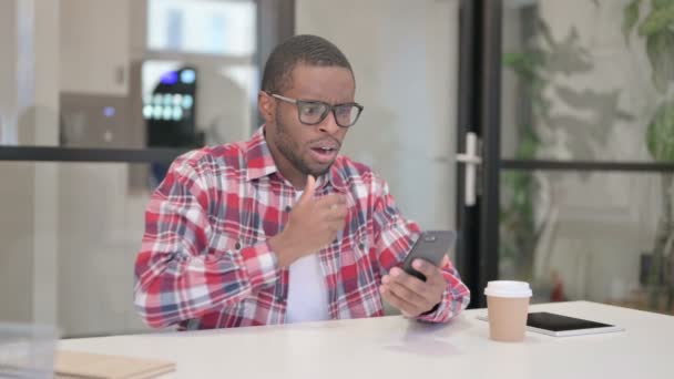 Homem Africano Perturbado Reagindo à Perda no Smartphone — Vídeo de Stock