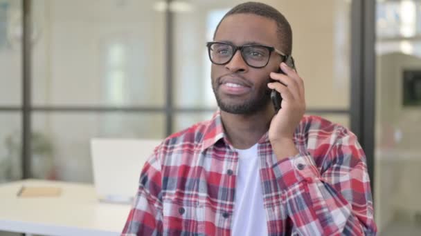 Afrikansk man pratar på telefon, diskuterar — Stockvideo