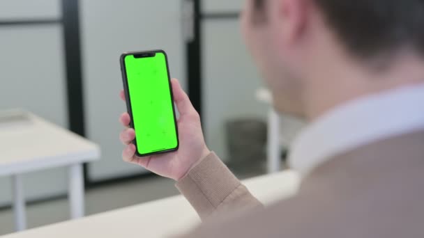 Vista posteriore dell'uomo guardando Smartphone con schermo cromato — Video Stock