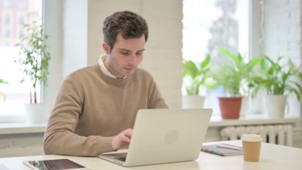 Man firar framgång när du använder laptop i Office — Stockvideo