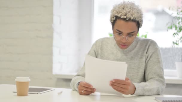 Afrikaanse vrouw viert succes tijdens het lezen van documenten in Office — Stockvideo