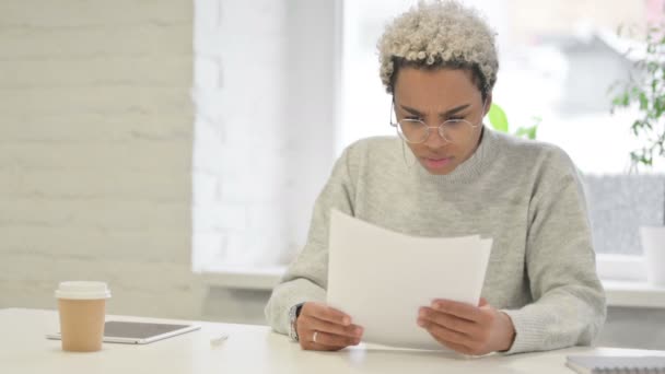 Afrikaanse vrouw geschokt tijdens het lezen van documenten in Office — Stockvideo