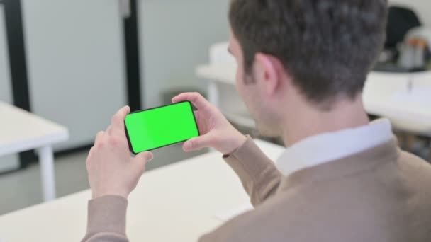 Vista posteriore dell'uomo guardando Smartphone con schermo cromato — Video Stock