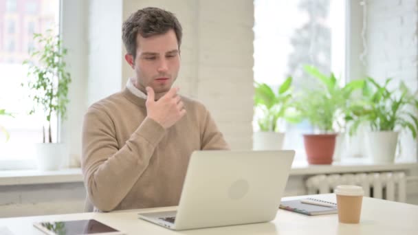 Homme pensant tout en travaillant sur ordinateur portable dans le bureau — Video