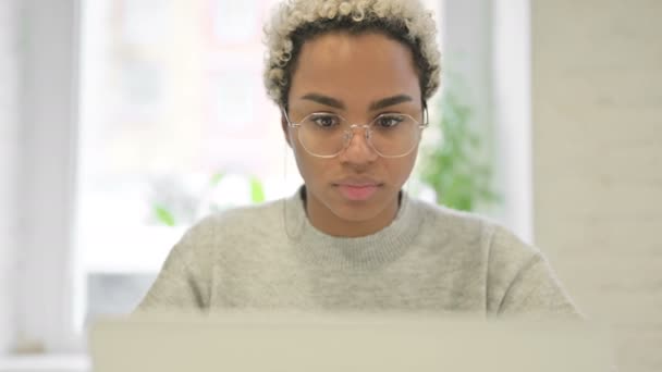 Nahaufnahme einer Afrikanerin, die Kopfschmerzen hat, während sie ihren Laptop benutzt — Stockvideo