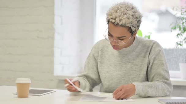 Африканская женщина пишет на бумаге в офисе — стоковое видео