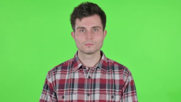 Portret van een serieuze jongeman kijkend naar de camera, Green Chroma Screen — Stockvideo