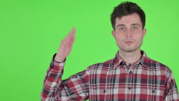 Portret van jonge man met product in de hand, groene chroma scherm — Stockvideo