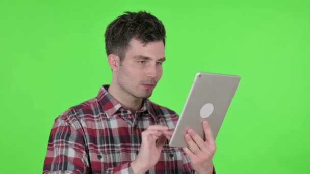 Retrato de un hombre joven celebrando el éxito en la tableta, Pantalla de croma verde — Vídeo de stock
