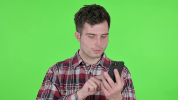 Retrato de hombre joven usando Smartphone, Pantalla de croma verde — Vídeo de stock