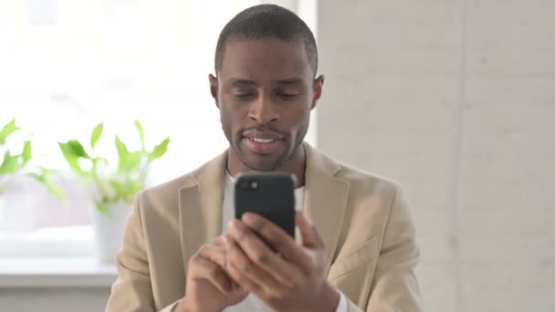 Retrato do homem africano comemorando no smartphone — Vídeo de Stock