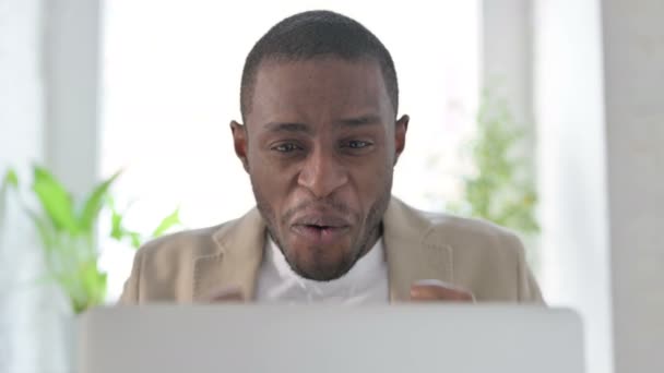 Close-up van Afrikaanse man vieren succes op laptop — Stockvideo