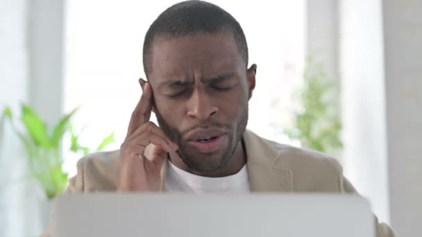 Close-up van Afrikaanse man met hoofdpijn tijdens het gebruik van laptop — Stockvideo