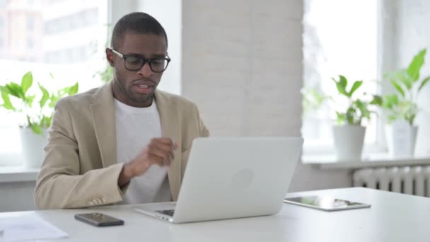 Hombre africano tosiendo mientras usa el ordenador portátil en la oficina — Vídeo de stock