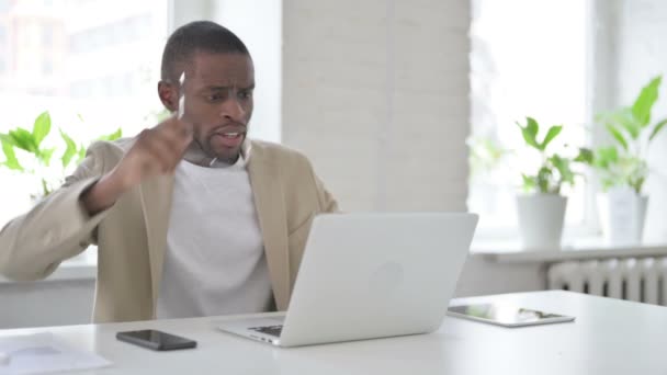 Homme africain réagissant à la perte tout en utilisant un ordinateur portable — Video