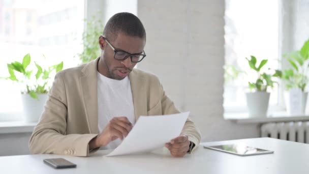 African Man Lezing Papers tijdens het Zitten in Office — Stockvideo