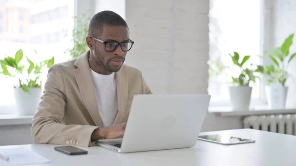 Hombre africano trabajando en el ordenador portátil en la oficina —  Fotos de Stock