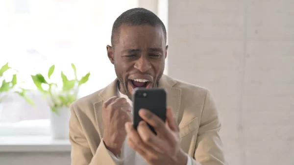 Retrato del hombre africano celebrando en Smartphone —  Fotos de Stock