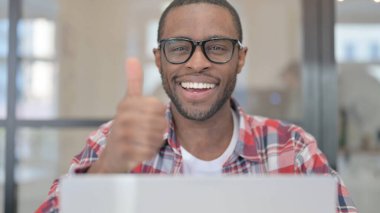 Dizüstü bilgisayarlı Afrikalı Adamı Kapat Başparmaklarını Göster