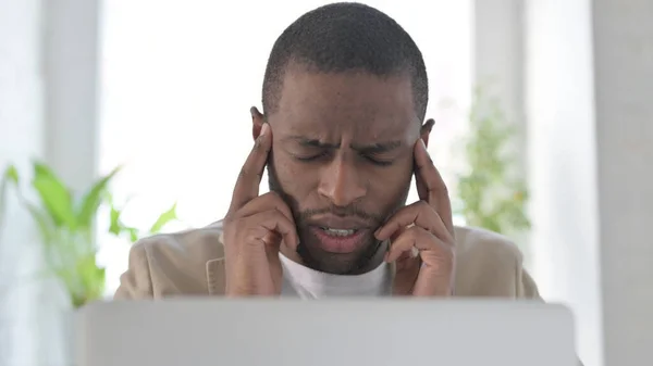 Κοντινό πλάνο του αφρικανικού ανθρώπου που έχει πονοκέφαλο κατά τη χρήση του Laptop — Φωτογραφία Αρχείου