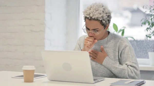 非洲妇女在办公室使用笔记本电脑时咳嗽 — 图库照片