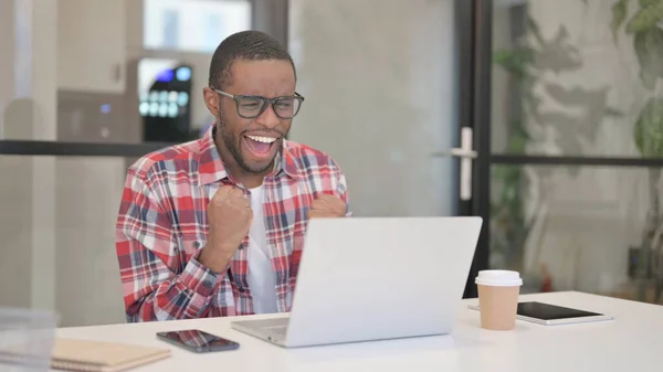 Afrikansk man firar framgång när du använder laptop — Stockfoto