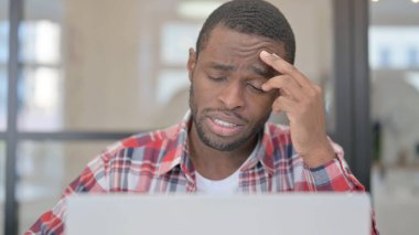 Dizüstü bilgisayar kullanırken Afrikalı Adam 'ın Baş Ağrısının Kapanışı