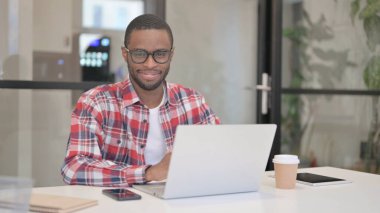 Dizüstü bilgisayarı olan Afrikalı Adam evet işareti olarak başını sallıyor.