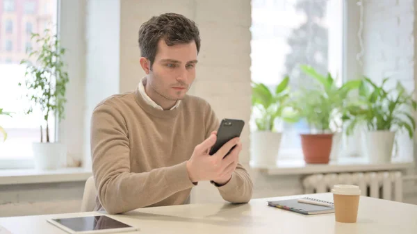 Homme attrayant en utilisant Smartphone dans le bureau — Photo