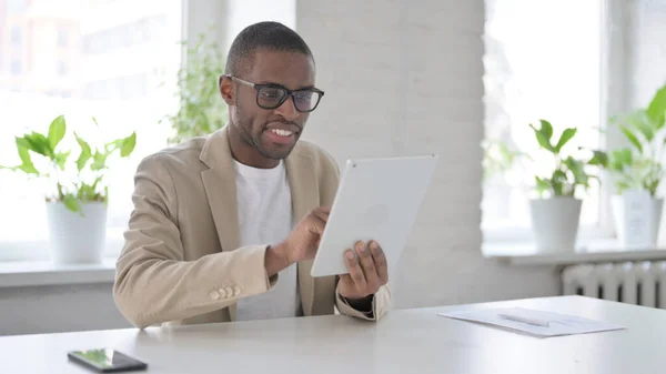 Hombre africano usando Tablet mientras está sentado en la oficina —  Fotos de Stock