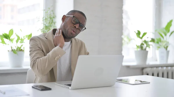 African Man having Neck Pain while using Laptop in Office — Stockfoto