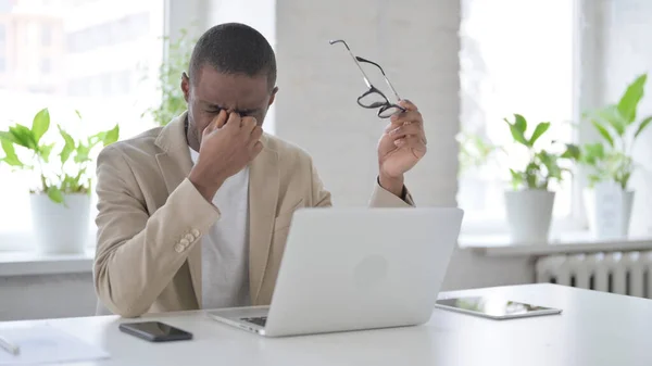 Afrikaanse Man heeft hoofdpijn tijdens het werken op laptop — Stockfoto