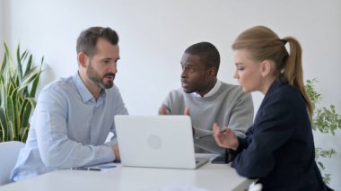 Ofiste Dizüstü bilgisayar kullanırken İş Adamları Tartışıyor