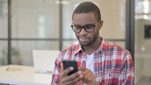 非洲男人使用智能手机，浏览互联网 — 图库照片