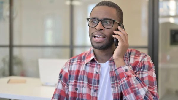 Afrikansk man pratar på telefon, diskuterar — Stockfoto