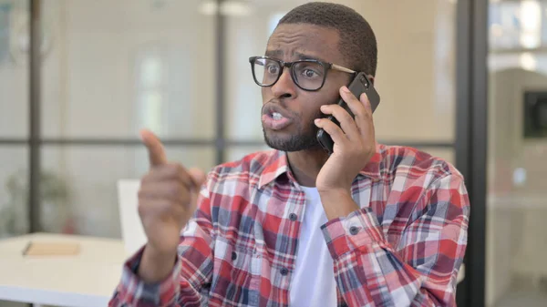 Perturbado hombre africano hablando enojado en Smartphone —  Fotos de Stock
