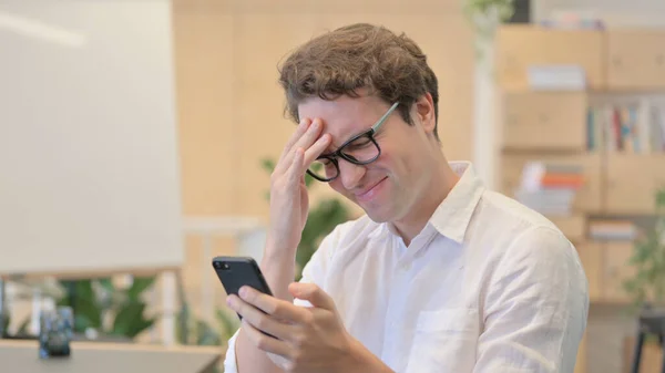 Portret młodego mężczyzny z utratą przytomności podczas korzystania ze smartfona — Zdjęcie stockowe