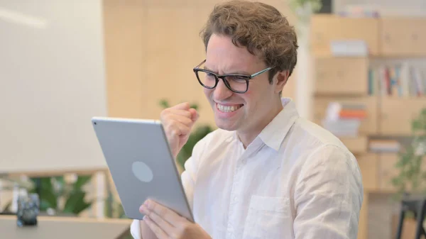 Portrait de jeune homme célébrant sur tablette au bureau moderne — Photo