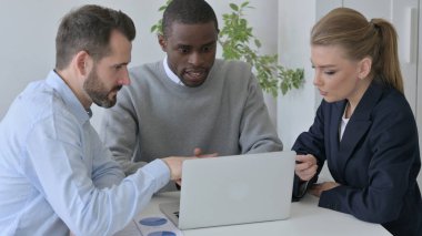 Karışık Irk İşadamları Ofiste Dizüstü bilgisayar kullanırken Ciddi Tartışıyorlar