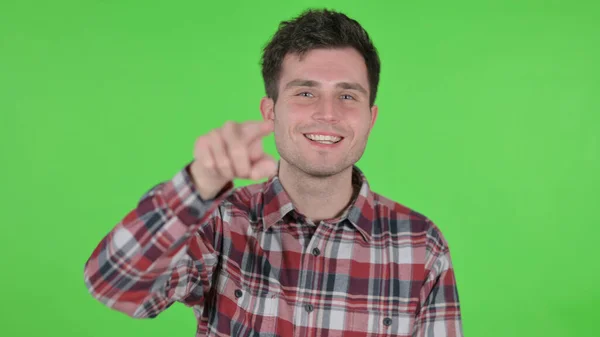 Retrato do jovem apontando para a câmera, tela Chroma verde — Fotografia de Stock