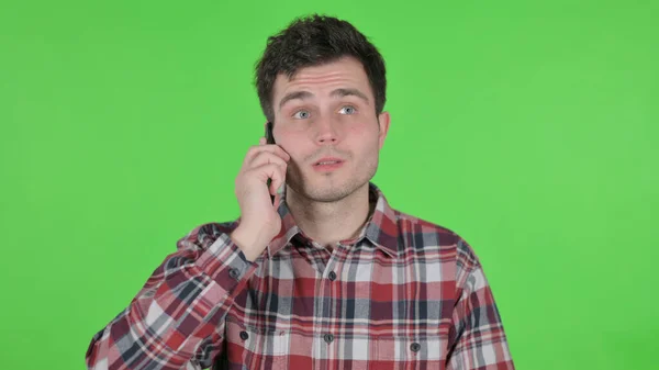 Portré fiatal férfi beszél telefonon, zöld Chroma képernyő — Stock Fotó
